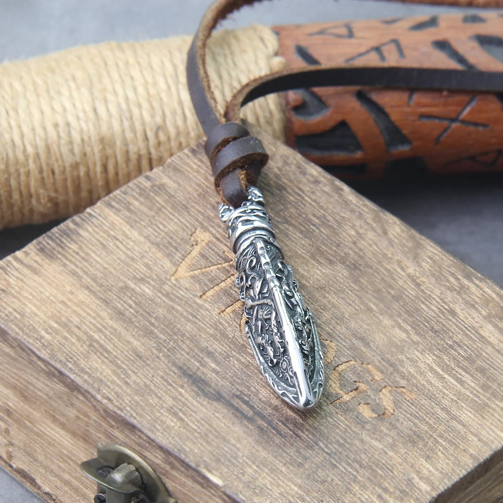 Celtic warrior necklace with intricate silver design on leather cord, displayed on wooden Viking box.