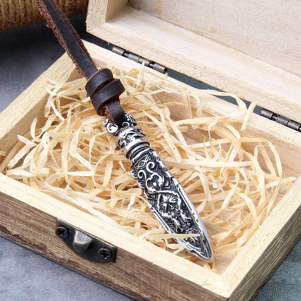 Decorative silver Celtic warrior arrowhead pendant in a wooden box with straw.