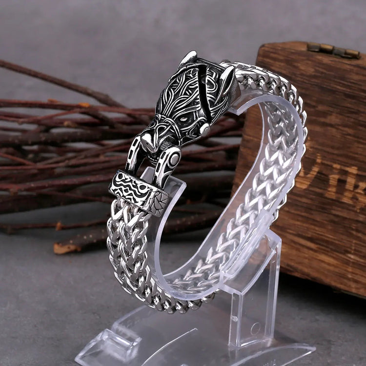 Bracelet featuring intricate Celtic wolf design, braided silver chain, and artisan craftsmanship.