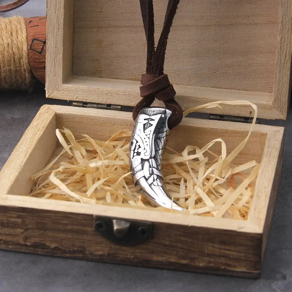 Celtic symbol necklace pendant displayed in a wooden box with straw, showcasing intricate design and leather cord.