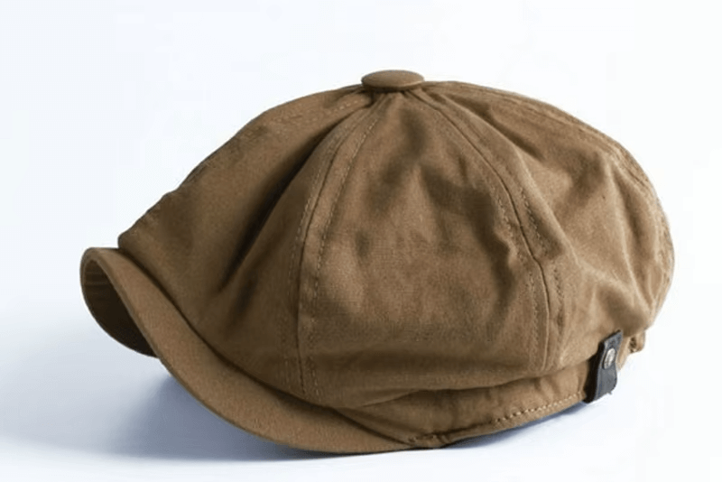 Casquette gavroche en tissu marron, angle latéral montrant le style classique et décontracté.