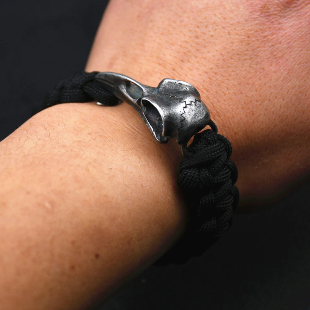 Bracelet viking corbeau en acier inoxydable avec un design de crâne, porté sur un poignet.