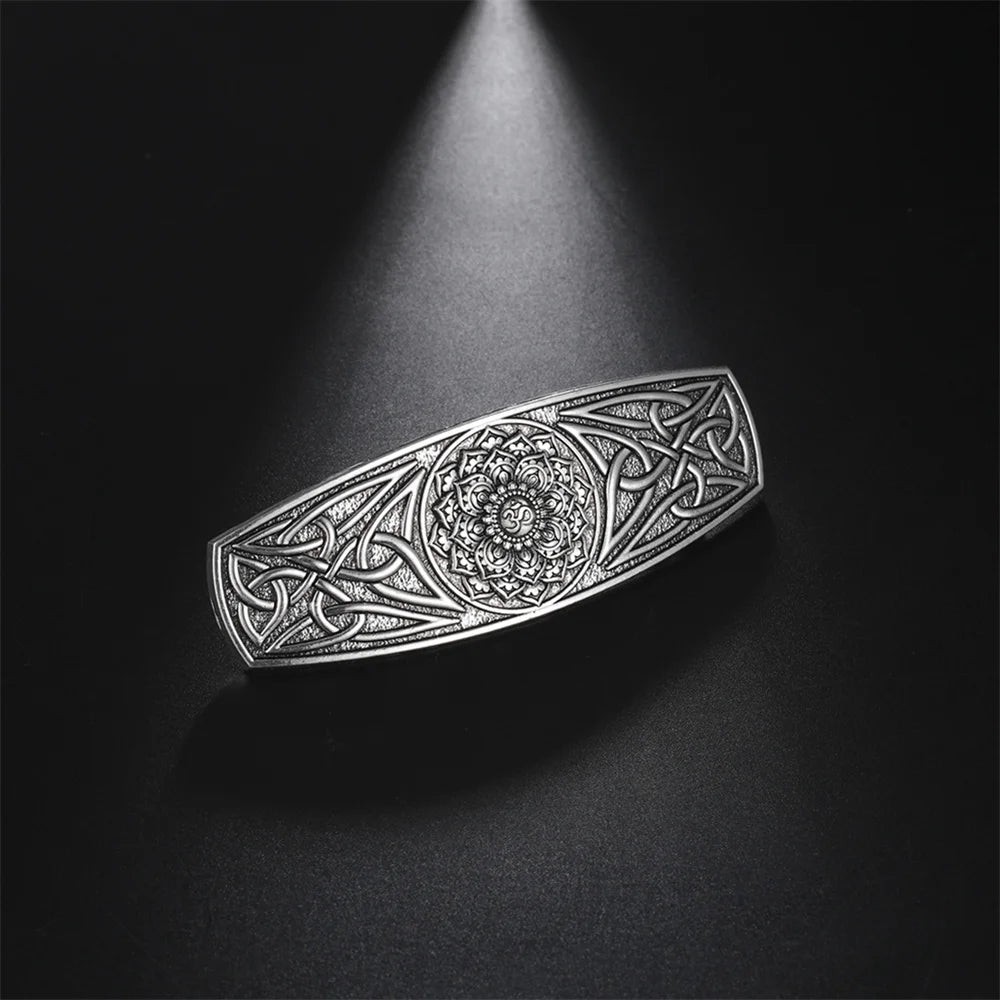 Celtic barrette with intricate silver design, highlighting dramatic lighting and detailed craftsmanship.