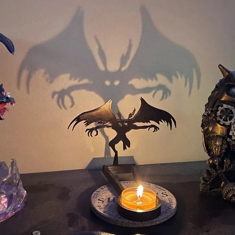 Projecteur d'ombre d'halloween avec ombre de chauve-souris projetée et bougie allumée sur une table.