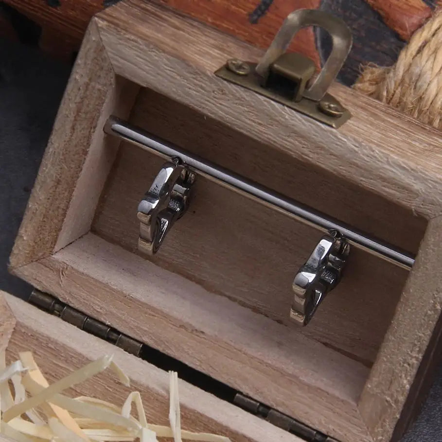 Boucles d'oreilles lacet en acier inoxydable créole, présentées dans une boîte en bois élégante.