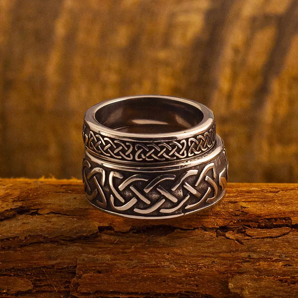 Bague Claddagh en acier inoxydable avec motif celtique, posée sur du bois rustique.