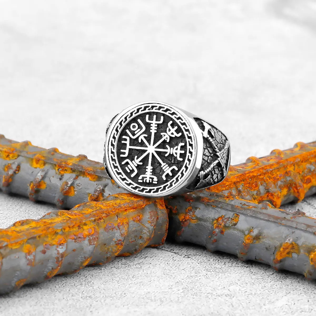 Bague runique viking ornée du symbole Vegvisir sur fond de métal rouillé, un bijou emblématique et élégant.