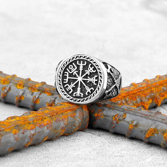 Bague runique viking ornée du symbole Vegvisir sur fond de métal rouillé, un bijou emblématique et élégant.