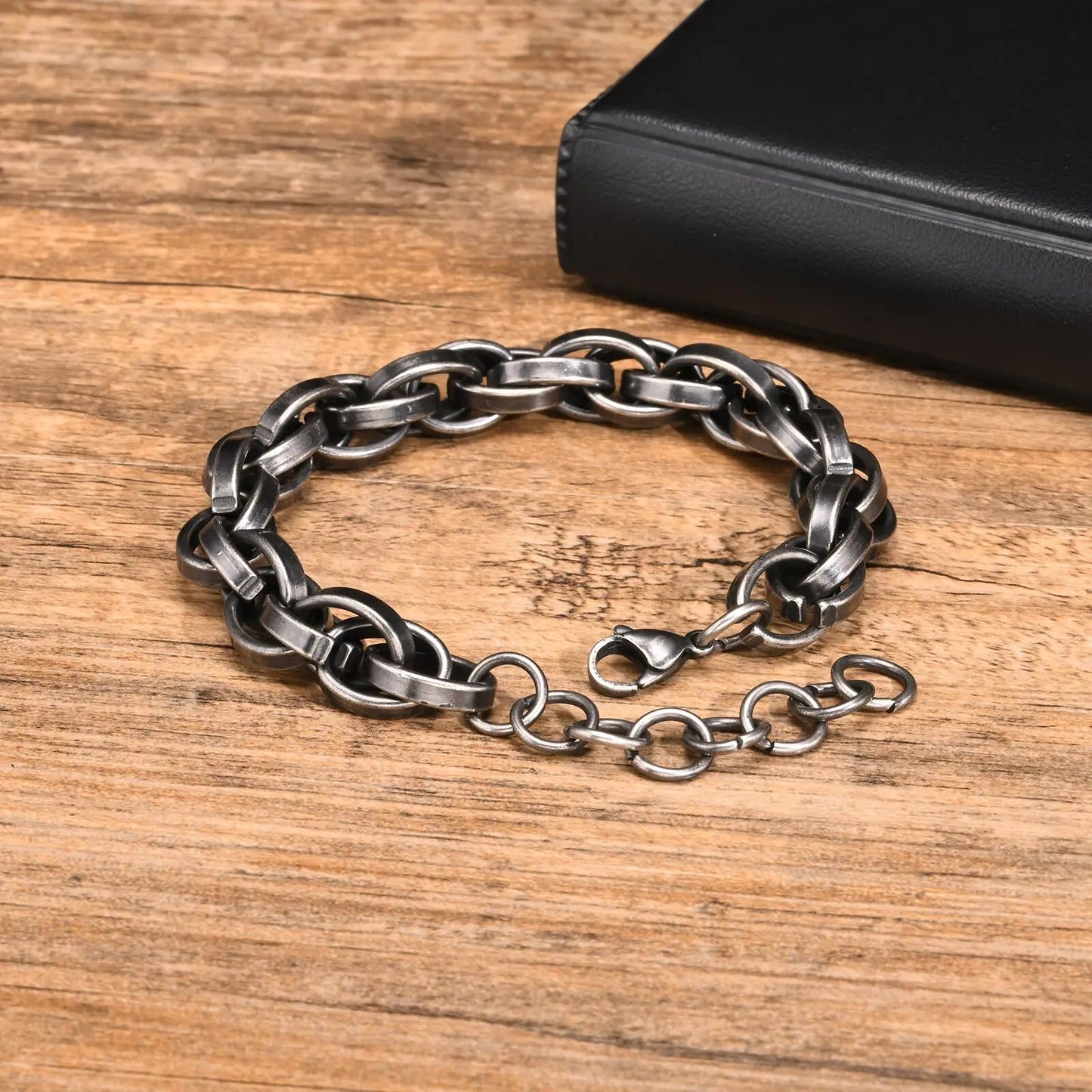 Bracelet chaine viking en acier inoxydable sur un fond en bois, avec un fermoir sécurisé.