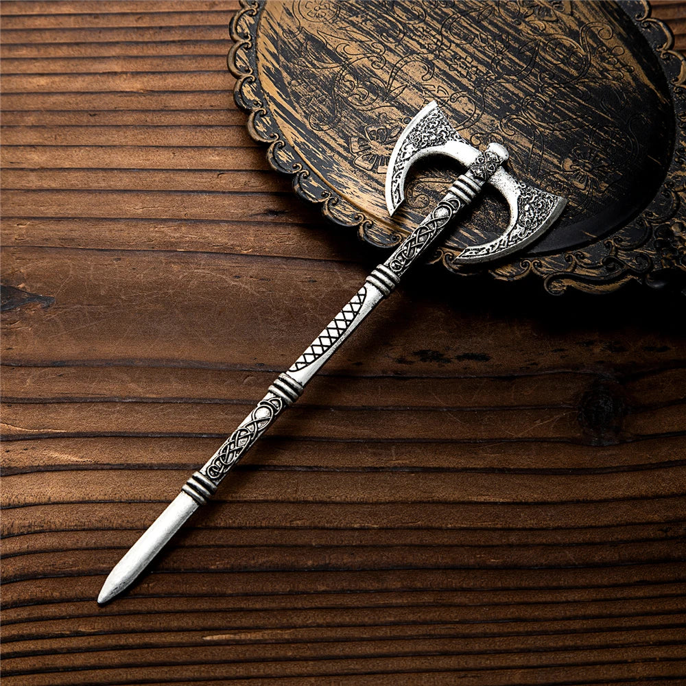 Épingle à cheveux hache Viking posée sur une assiette décorative en bois.