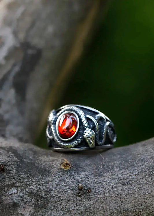 bague du sorcier en acier titane ornée de zirconium sur une branche en bois.
