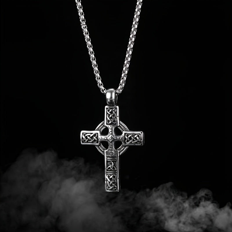 Pendentif croix celtique en acier inoxydable avec finition rustique sur un fond noir.